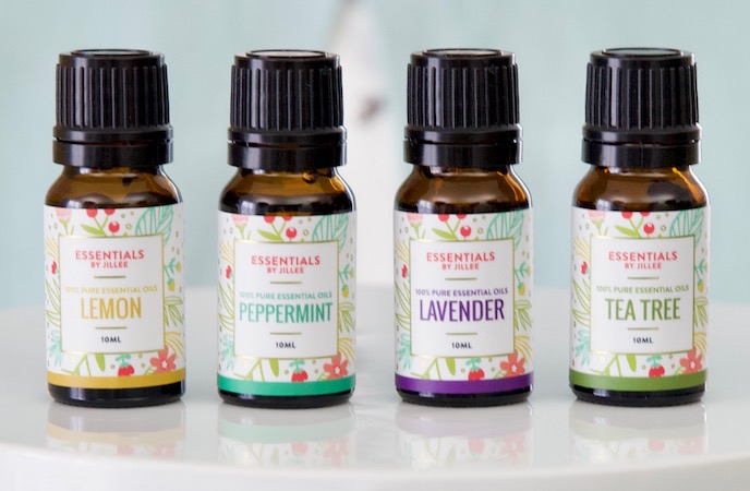 Four bottles of essential oils on a white plate, showcasing one good thing for modern homemaking.