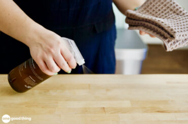 Cleaning with essential oils Homemade dusting spray being sprayed on a wood surface