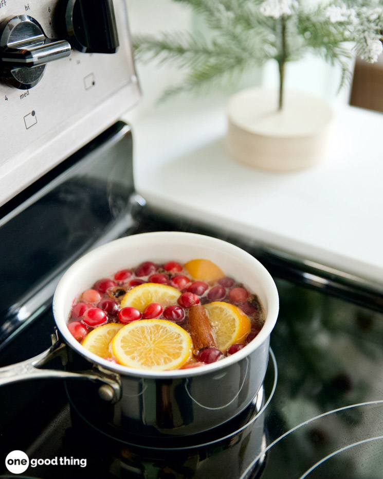 A pot with cranberries and oranges on the stove.