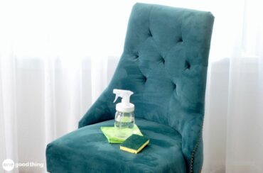 A chair with a bottle of cleaning spray on it, demonstrating how to clean a microfiber couch.