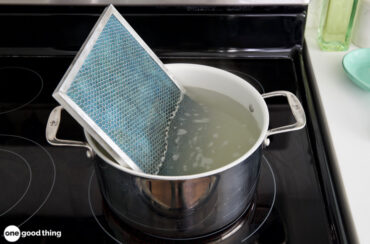 A pot filled with water on top of a stove, while learning how to clean your range hood filter.