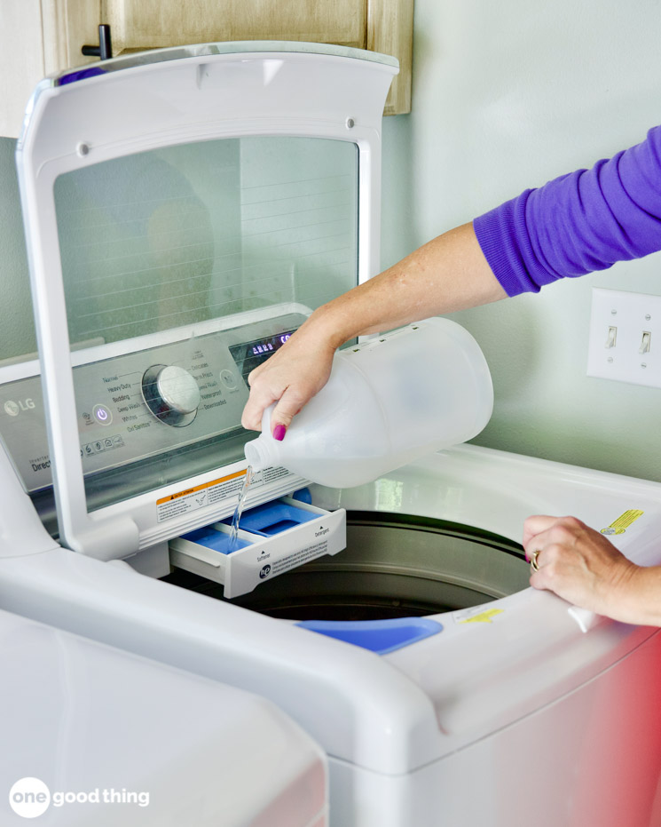 Solving Laundry Problems - pouring white vinegar into washing machine tray