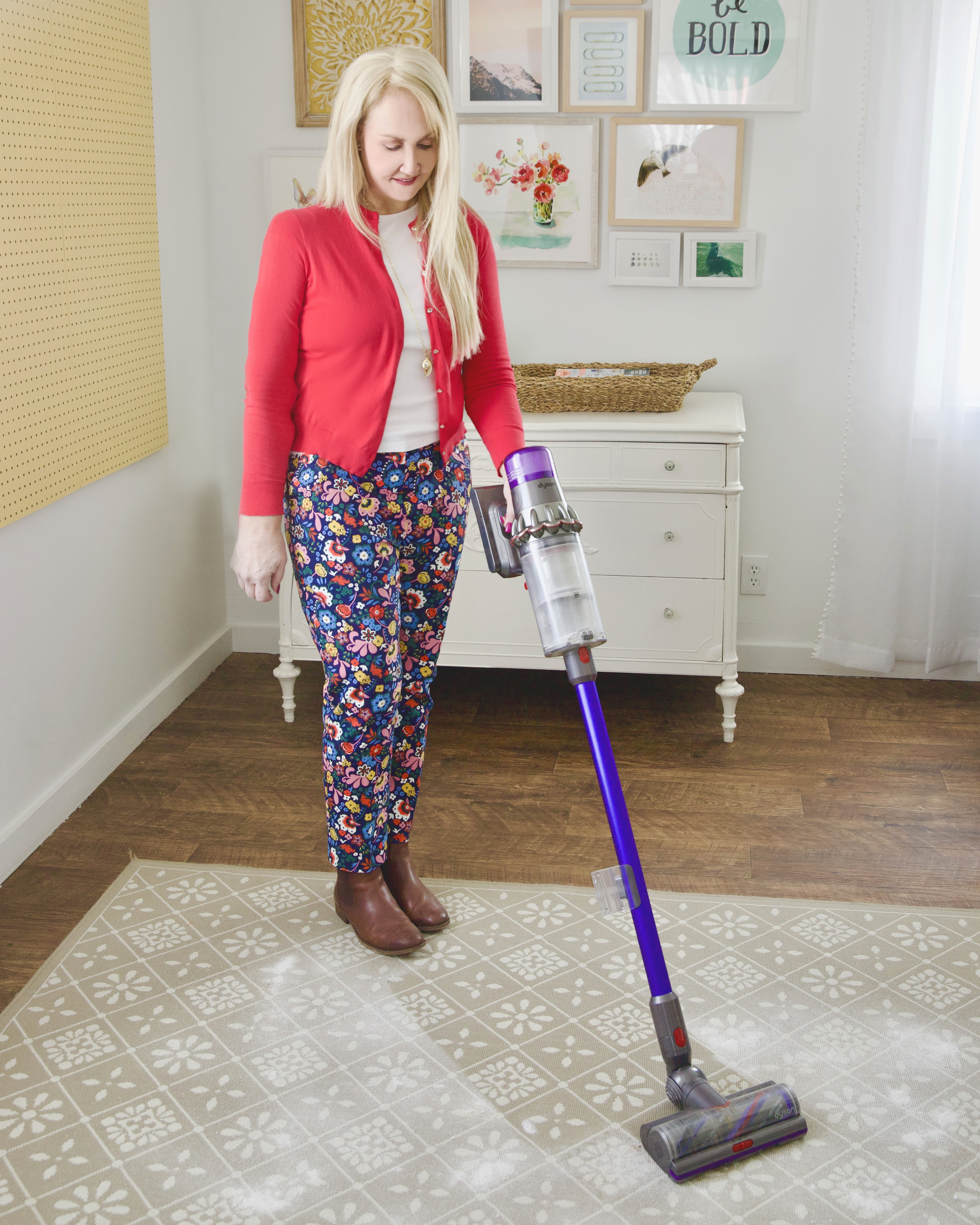 blond woman using cordless vacuum to get powder off rug