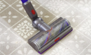 A vacuum cleaner on a tiled floor, with carpet powder.