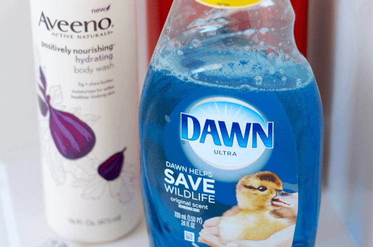 Dawn dish soap sitting on a shower shelf with a razor and body wash