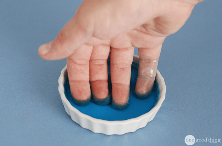 fingers dipped into a saucer with blue dawn dish soap