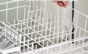 Person pulling out the bottom rack of a dishwasher, with text "3 easy steps on how to clean a dishwasher" on the image.